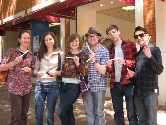 A group poses with their poem scrolls on the Charlottesville Downtown Mall.